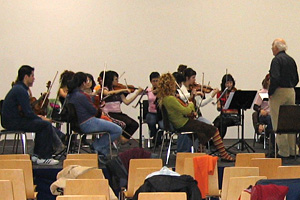 Fotografía na que pode verse unha clase da Escola de Altos Estudos Musicais, na que varios alumnos están a tocar o violín.